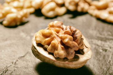 Walnut whole half shelled on slate background. Close up, selective focus.