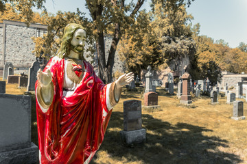Fototapeta na wymiar Red Jesus Christ Statue in an American Cemetery
