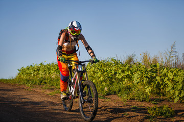 Extreme sports - young woman riding downhill bike