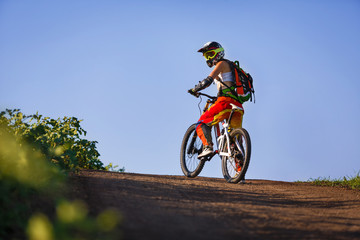 Naklejka premium Extreme sports - young woman riding downhill bike