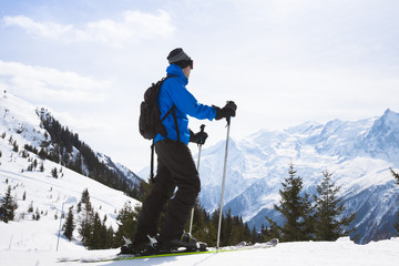 Skier looking at beautiful panorama with mountain range in backg