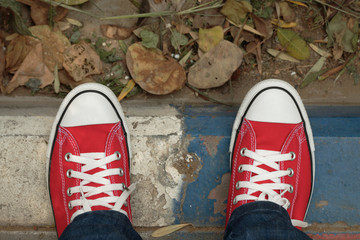 Red canvas sneakers on a sidewalk
