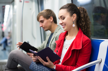 Passengers reading in metro wagon.