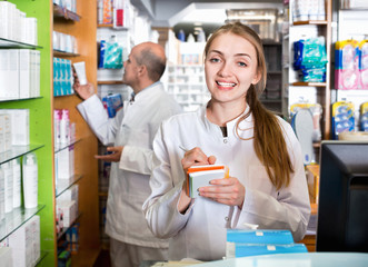 Fototapeta na wymiar Smiling pleasant pharmacist and pharmacy technician