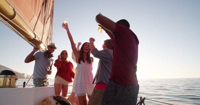 mixed race Group of friends enjoying a sunset yacht party
