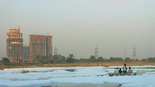 Locked-on shot of People rowing boat in river, Yamuna River, Delhi, India