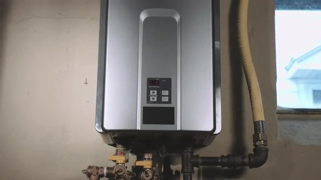 a front angle closeup shot of camera moving back on tankless water heater in the basement