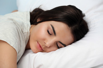 Fototapeta na wymiar Young woman in pajamas sleeping on bed, close up