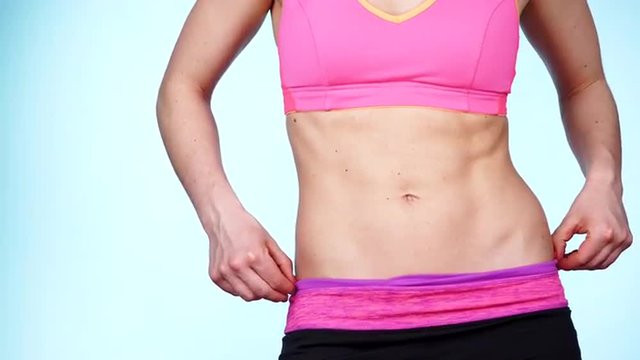 Woman showing some strong abs and flat belly close up 4K