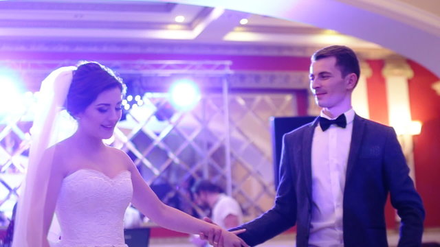 Wonderful young couple in love dancing their first valse in a restaurant.