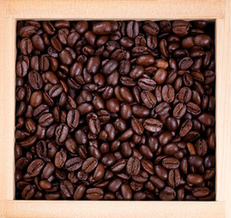Fototapeta premium Freshly roasted coffee beans in wooden box frame