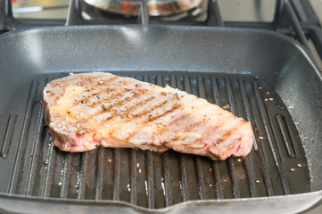 Beef tenderloin steak with pepper on a grill pan