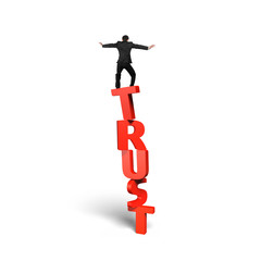 Man standing balancing on red vertical trust word