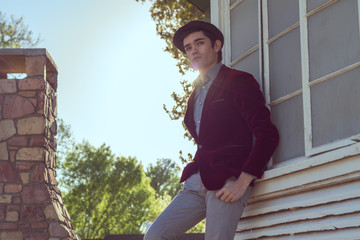 Portrait of young fashionable beautiful man in park wearing fedo
