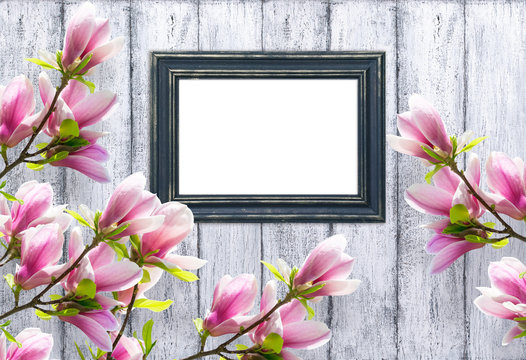 Magnolia and photo frame on background of shabby wooden planks