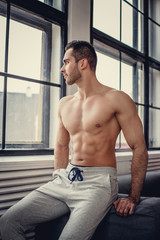 Shirtless muscular man with beard.