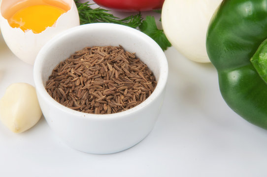 cumin seeds in white bowl with foodstuffs