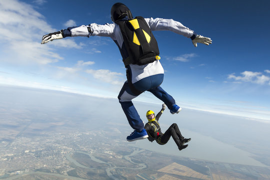 Girl and guy skydivers in freefall.