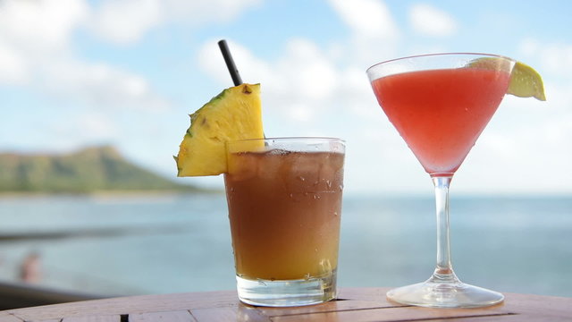 Drinks cocktails on tropical beach. Alcoholic drink close up on Waikiki Beach, Oahu, Hawaii. Typical Hawaiian drinks including Mai Tai.