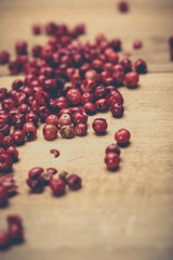 Heaps of pink pepper on a wooden table