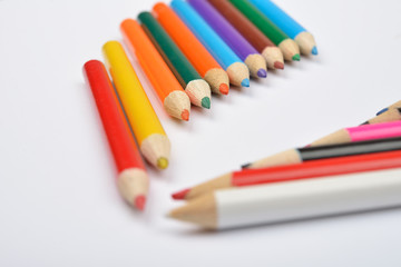 Close up picture of many little colored pencil crayons on white