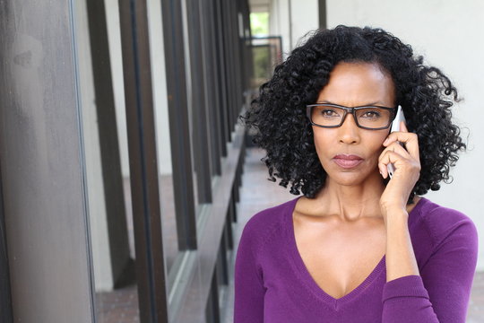 Angry African American business woman talking on cell phone. Isolated on office building with copy space. 
