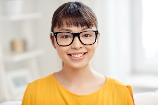 happy asian young woman in glasses at home