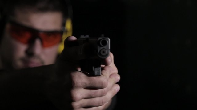 Holding a pistol over black background