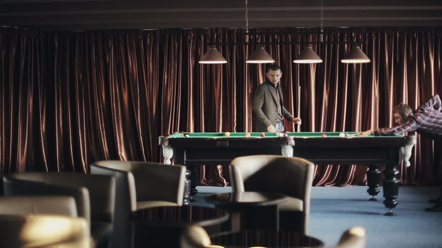 Friends are playing pool billiards