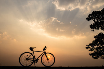 Silhouette of a bike on sky background on sunset