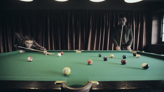 Friends are playing pool billiards