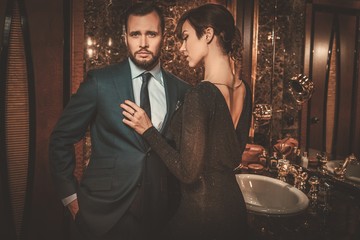 Well-dressed couple in luxury bathroom interior.