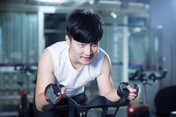 young handsome asian man works out in modern gym