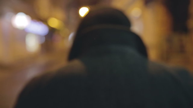 Silhouette of a man walking the night streets.