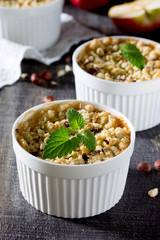 Dessert crumble with apple and nuts on a dark wooden table