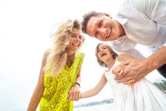 Laughing Young Family On The White Sky Background.