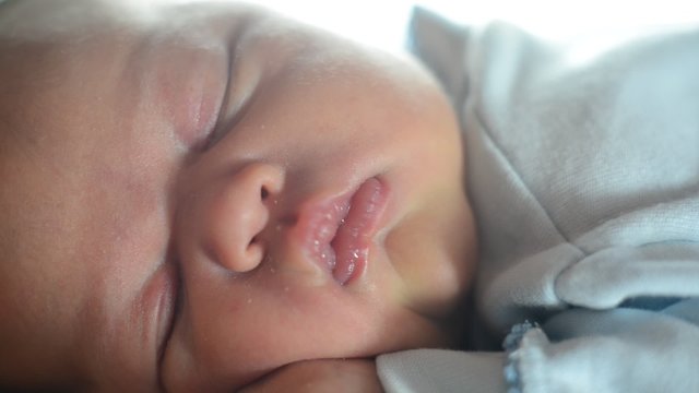 Neugeborenes Baby schl&auml;ft auf dem Bauch der Mutter