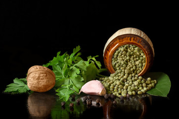Chick peas, parsley and spices on a black background.