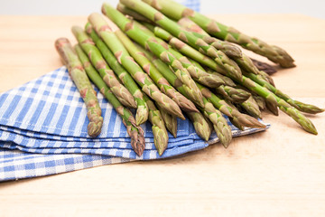 Fresh asparagus stems in a blue and white textile napkin