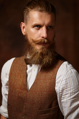 Portrait of brutal mustached bearded man in shirt and vest