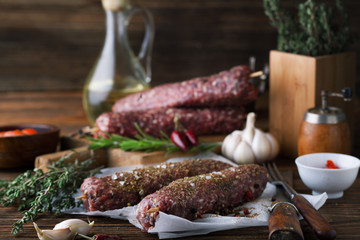 Raw minced meat on skewers with rosemary, garlic and spices