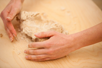 Kneading dough, preparing homemade bread out of spelt flour.