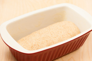 Hand kneaded dough for spelt bread rising in baking sheet.