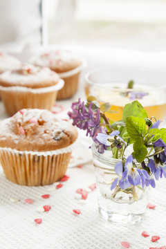 Blue spring flowers viola, muffins and cup of green tea