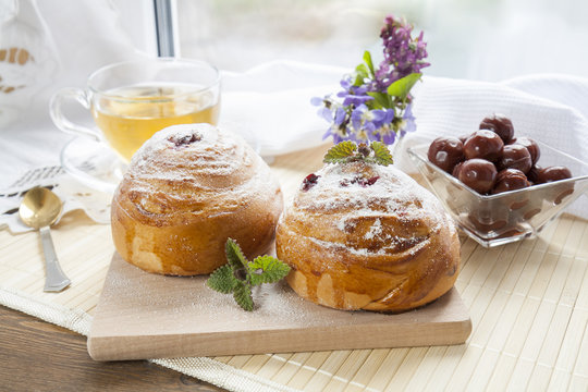 Tasty rolls with with lemon balm on wooden board