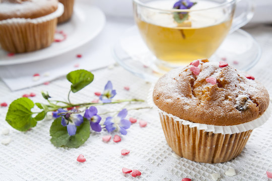 Tasty muffins with sugar hearts and cup of green tea