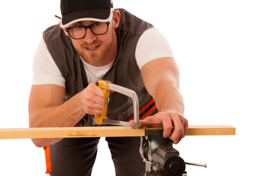 Young carpenter cuts a wooden lath with a saw isolated over whit