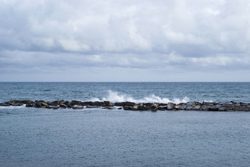 Stone breakwater with breaking waves