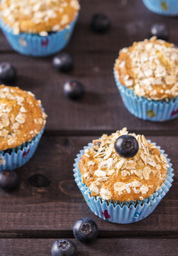 Oat muffins with blueberries on a dark wooden background 