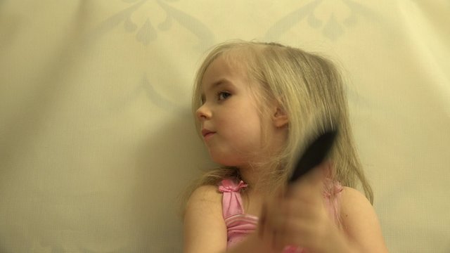 Girl Toddler Child Hair Dresses herself with a Hair Comb and Bru. 4K UltraHD video.